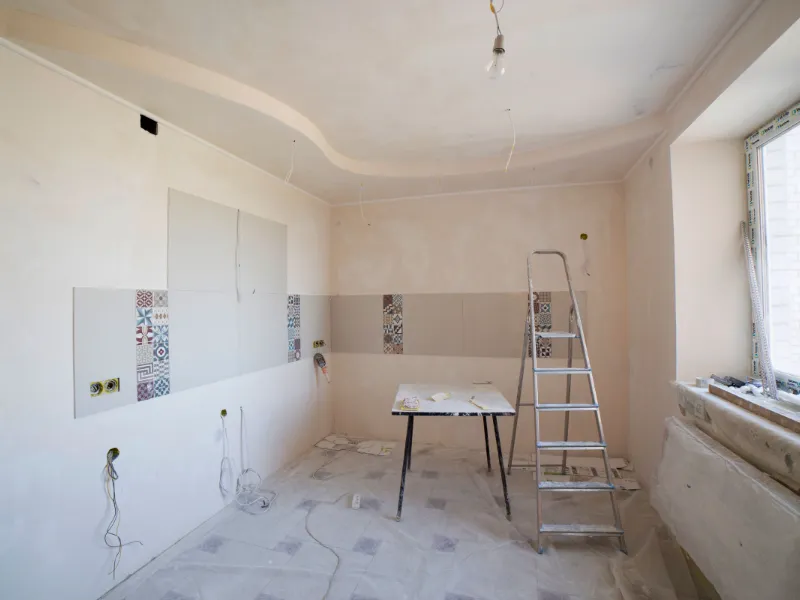 Vivienda en obra, con la pared a medio picar y material apilado