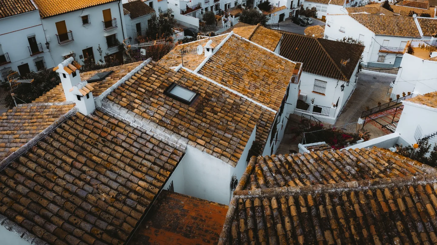 Tejados de un pueblo andaluz sobre la ladera, con el campo detrás